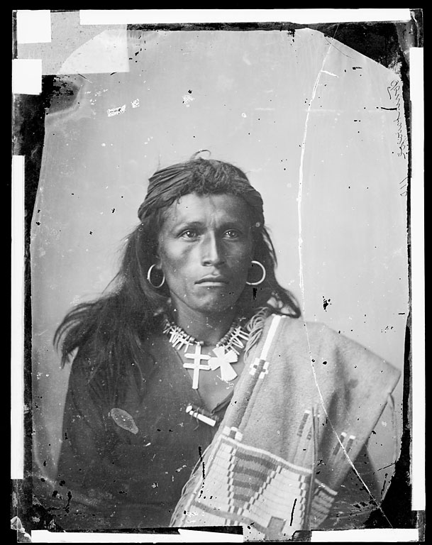 Picture shows portrait of Tom Torlino, in partial native dress and wearing silver cross necklace in 1882 upon his arrival at the boarding school.