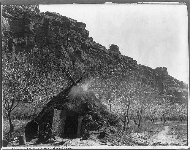 Picture shows Havasupai woman seated in doorway of summer wickiup in Cataract Canyon, ca. 1903.