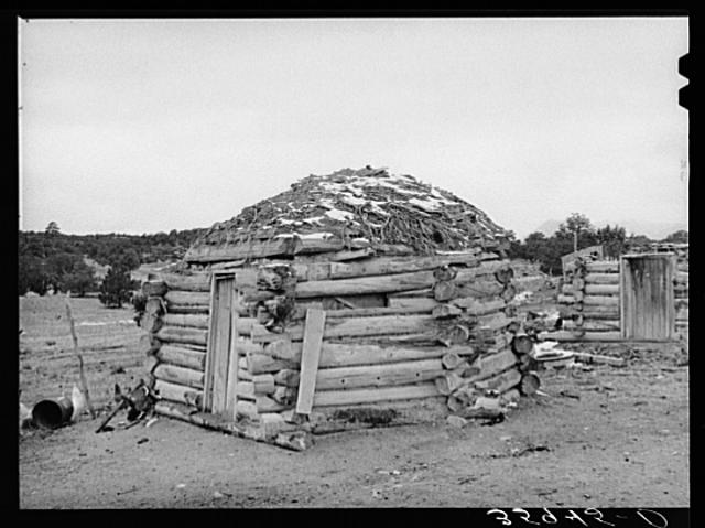 Picture shows later style hogan made of cribbed logs, 1940.